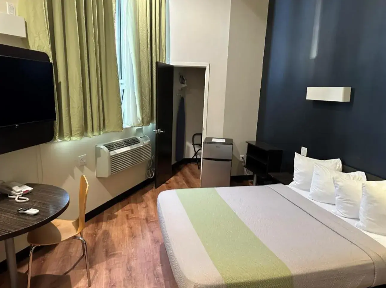 King Room mit blauer Wand, Schrank mit Bügelbrett und Minikühlschrank