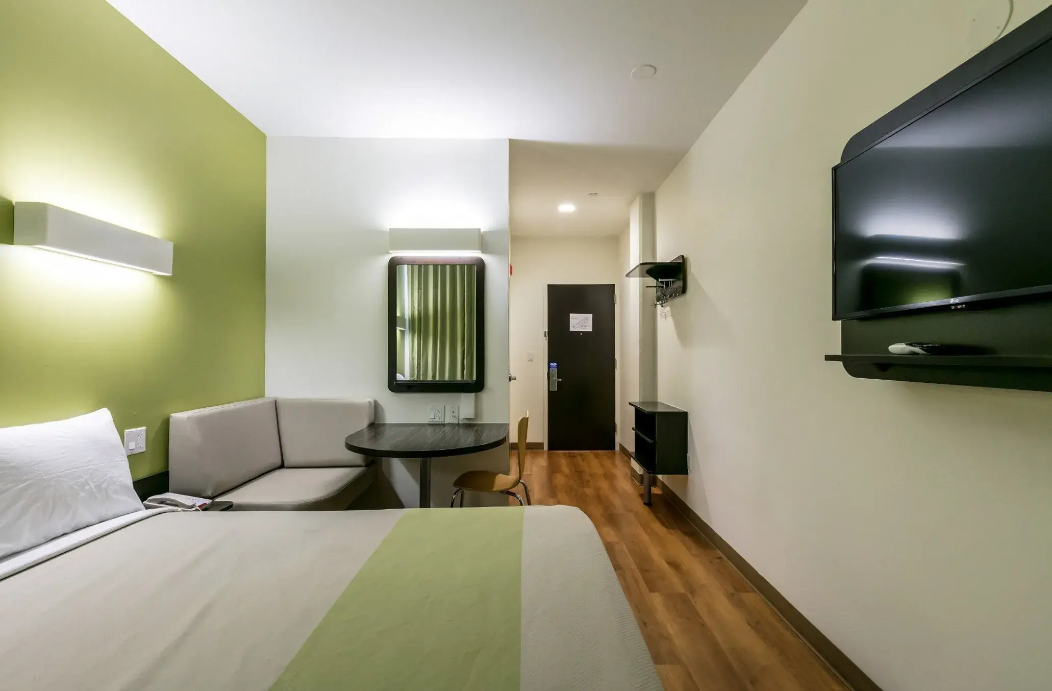 Zimmer mit Sofaecke, Tisch und Fernseher, Blick zur Eingangstür