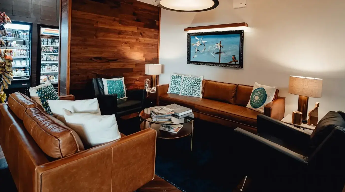 Lounge mit Ledersofas, Sesseln und dem Hotelshop im Hintergrund